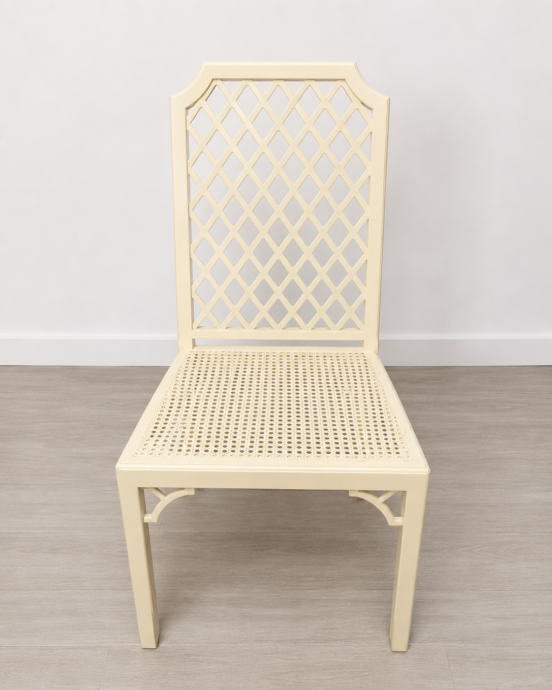 Silla blanca estilo bambú con asiento de rejilla